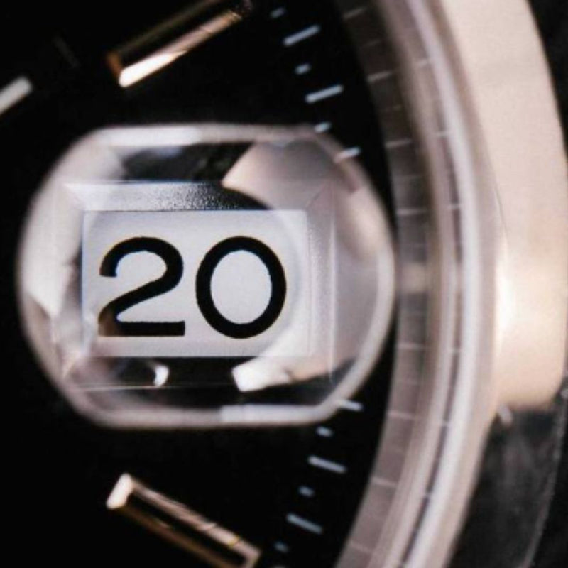 A close up of the date cyclops on a luxury watch face