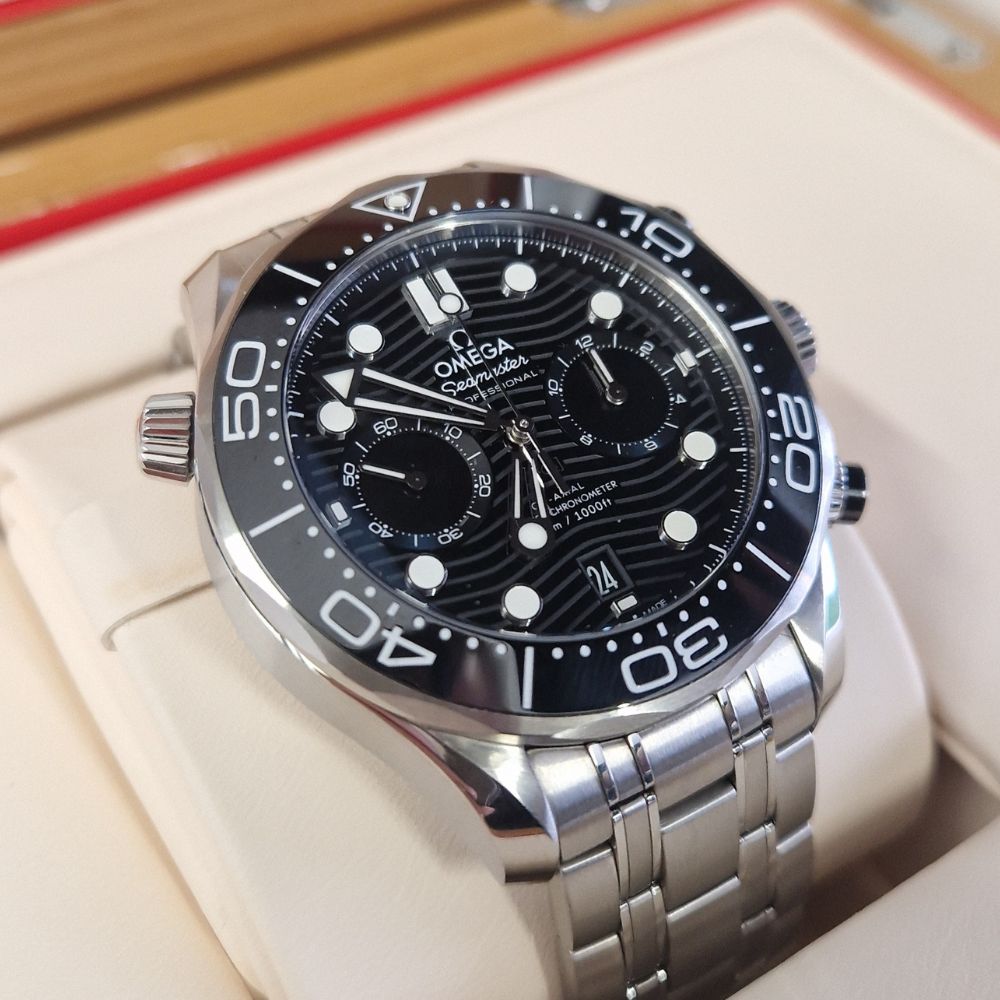 A close up of an Omega Seamaster watch with a black face and silver strap