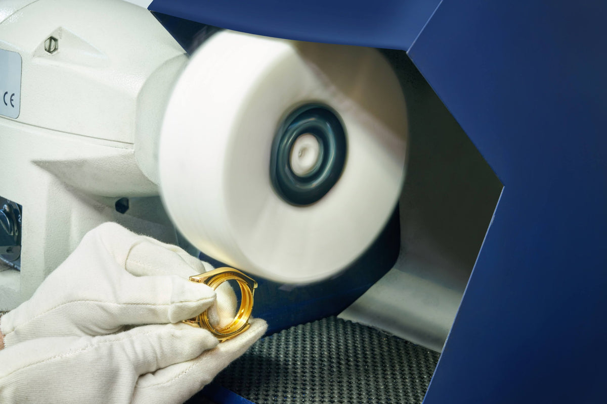 A gold watch case being polished