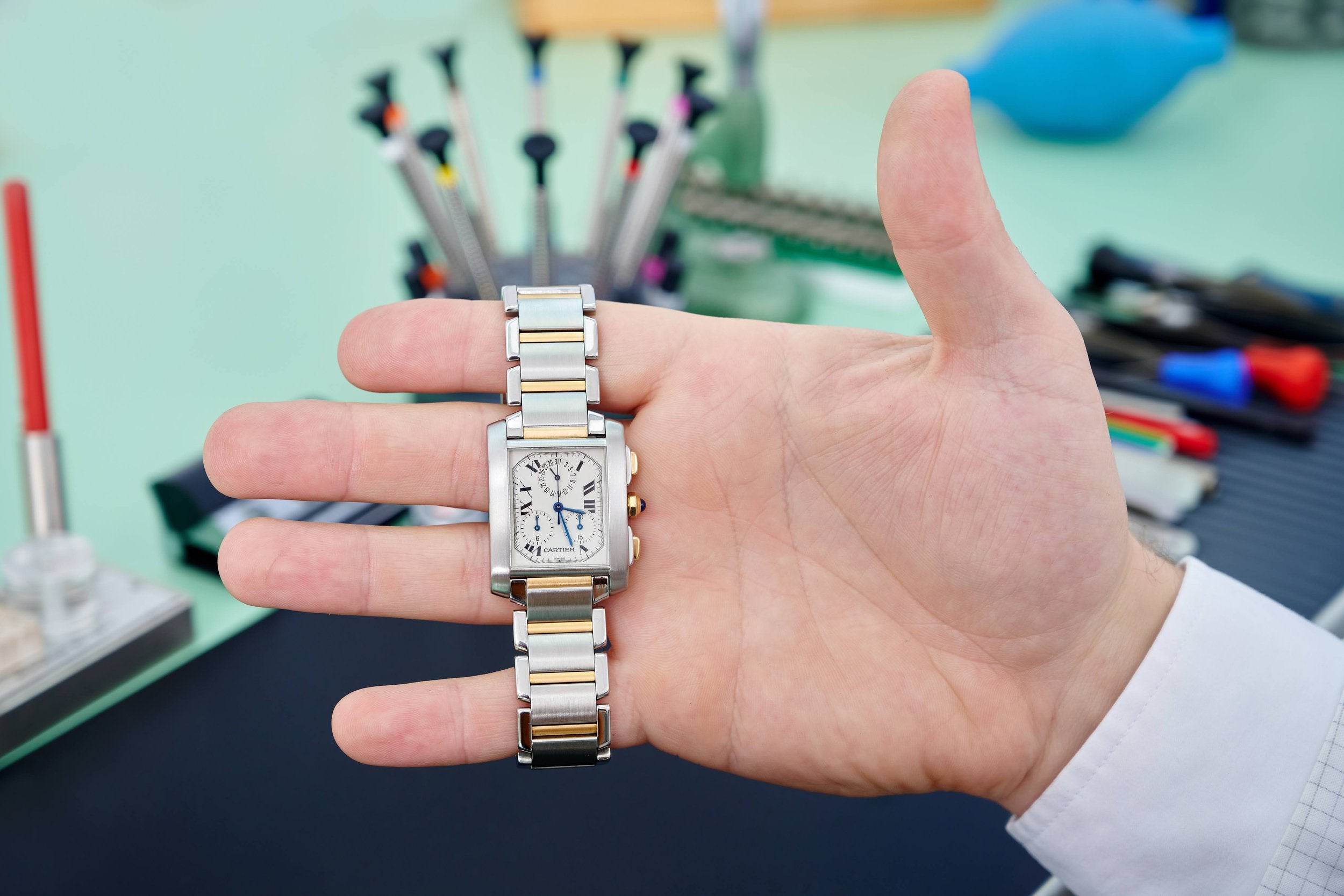 Watch technician holding a Cartier luxury watch