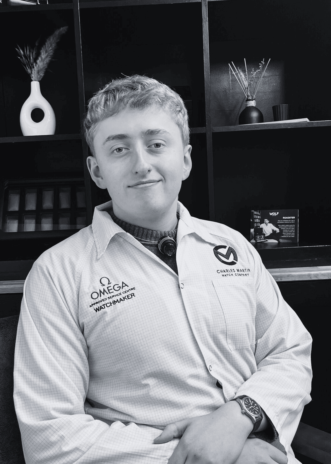 Person wearing a white shirt with Omega and Charlie Bank logos in an indoor setting.